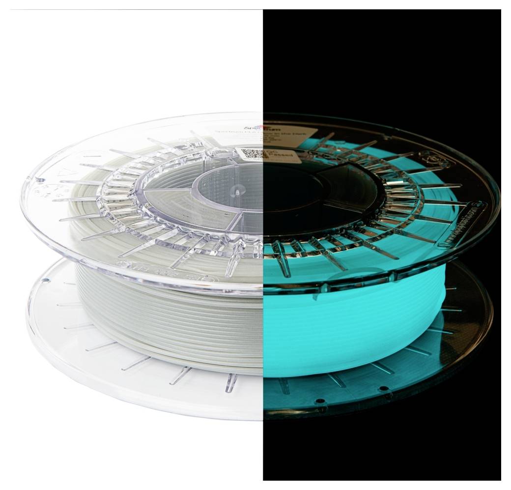 Une bobine de filament d'impression 3D, moitié visible sous une lumière normale en blanc, moitié brillant d'un bleu vif dans l'obscurité, illustrant l'effet phosphorescent.