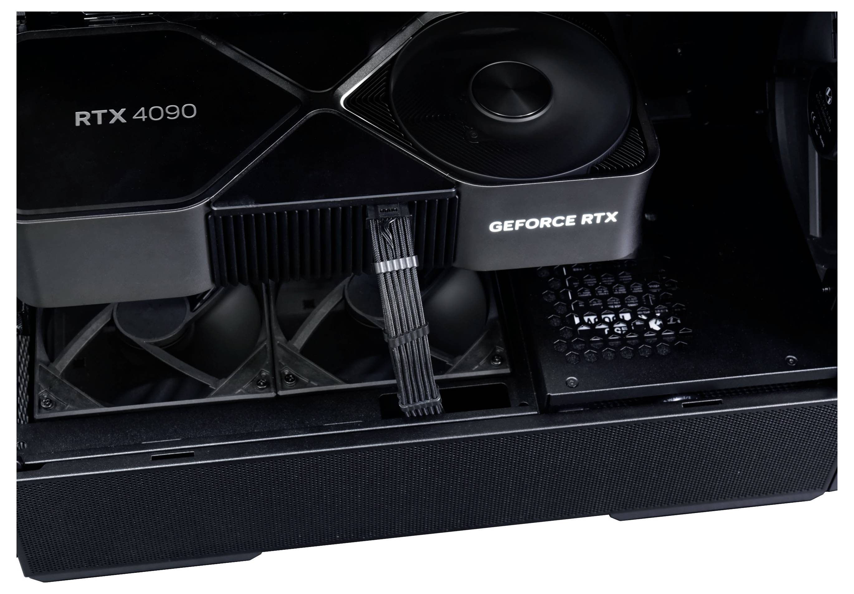 Une carte graphique Nvidia RTX 4090 noire à l'intérieur d'un boîtier d'ordinateur. La carte occupe une portion importante du champ de vision, avec des ventileurs visibles en dessous.