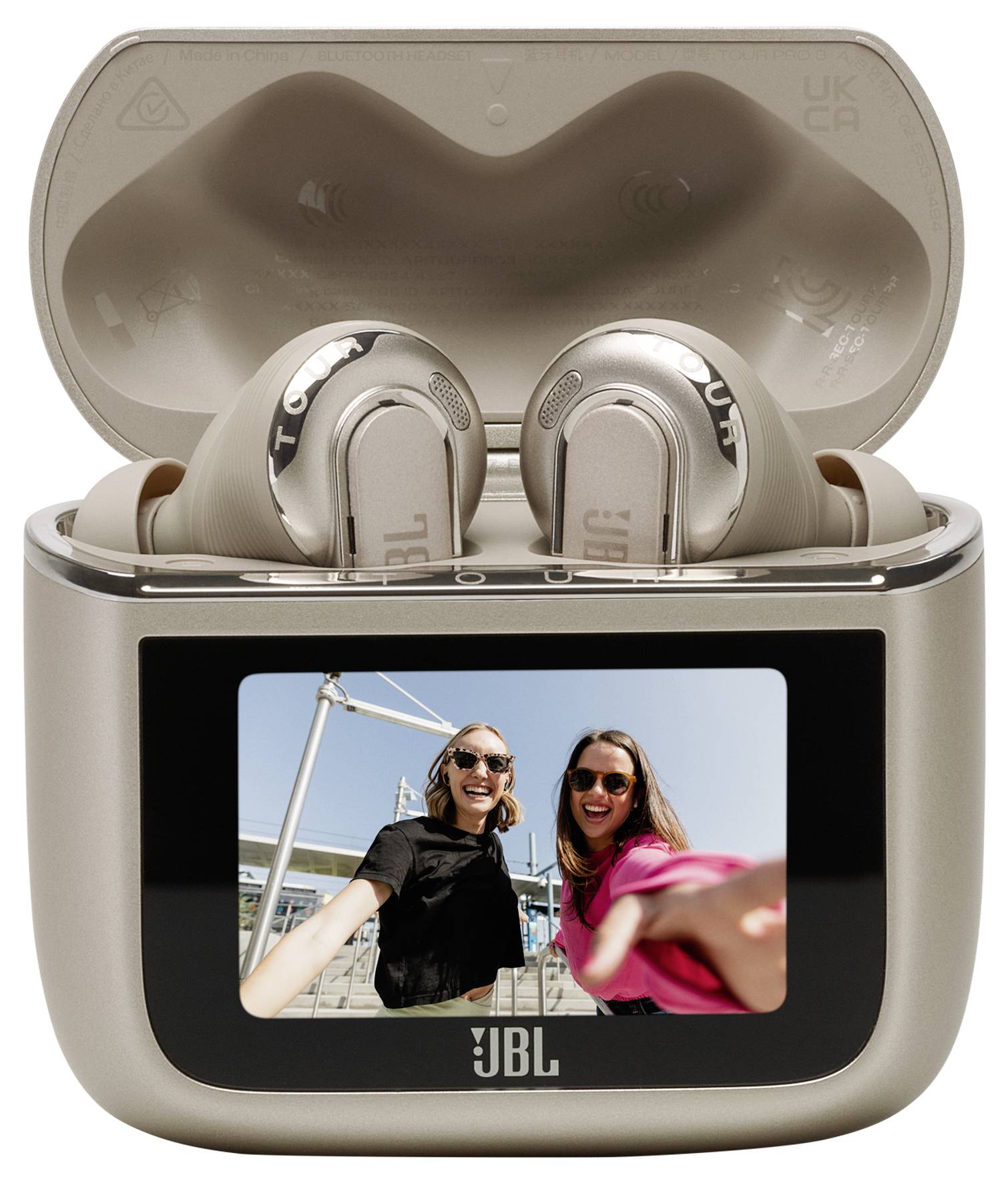 Écouteurs dans un boîtier de charge avec un écran montrant deux personnes souriantes prenant un selfie en extérieur.