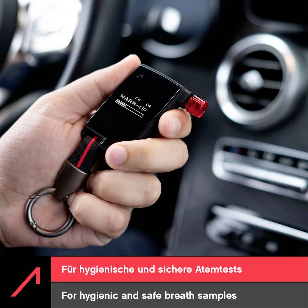 Une main tient un éthylotest personnel dans l'intérieur d'une voiture, affichant le message « PRÉCHAUFFAGE ». Le texte indique « Pour des échantillons d'haleine hygiéniques et sûrs. »