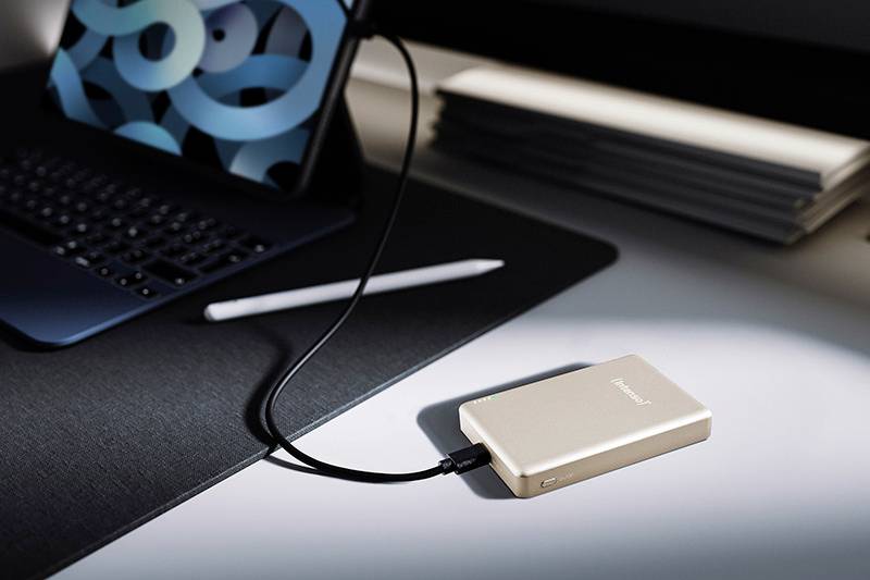 Une tablette et un clavier sur un bureau avec un stylet numérique. Un périphérique de stockage externe est connecté à la tablette via un câble.