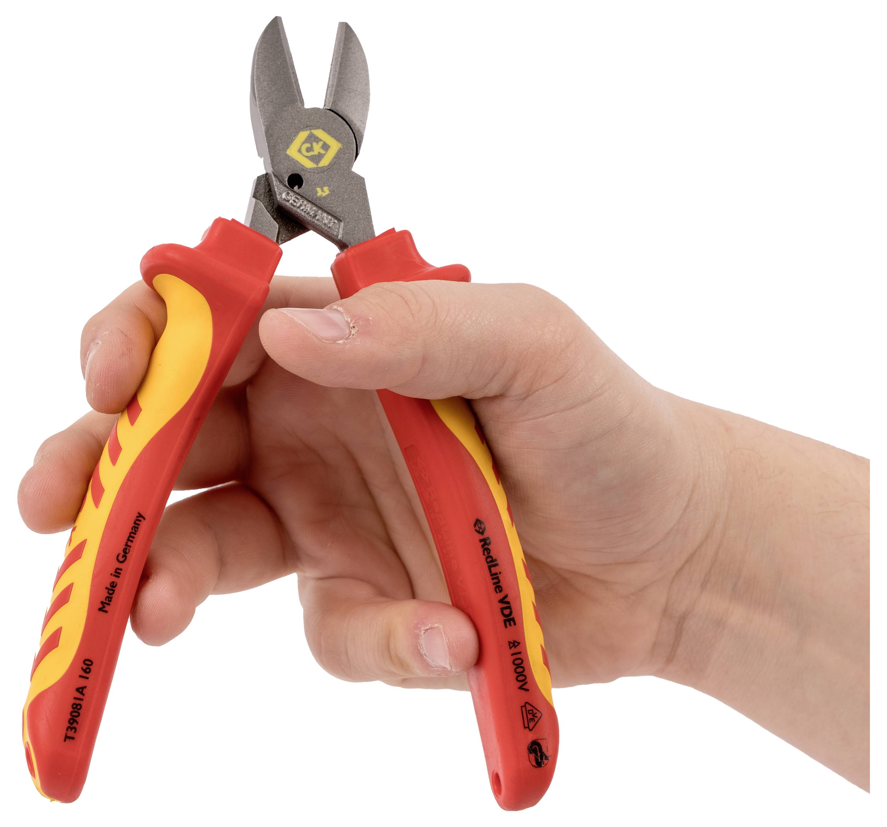 Une main tenant des coupe-câbles isolés avec des poignées rouges et jaunes, utilisés pour couper des fils. L'outil est marqué de certifications de sécurité.