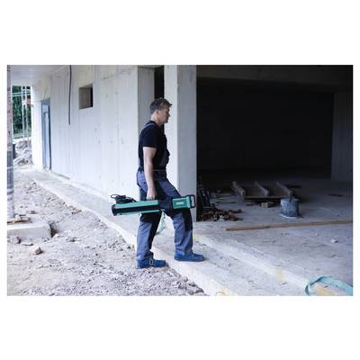 Une personne en tenue de travail utilisant un appareil de scan laser sur un chantier de construction. La zone est partiellement construite avec des surfaces en béton visibles.
