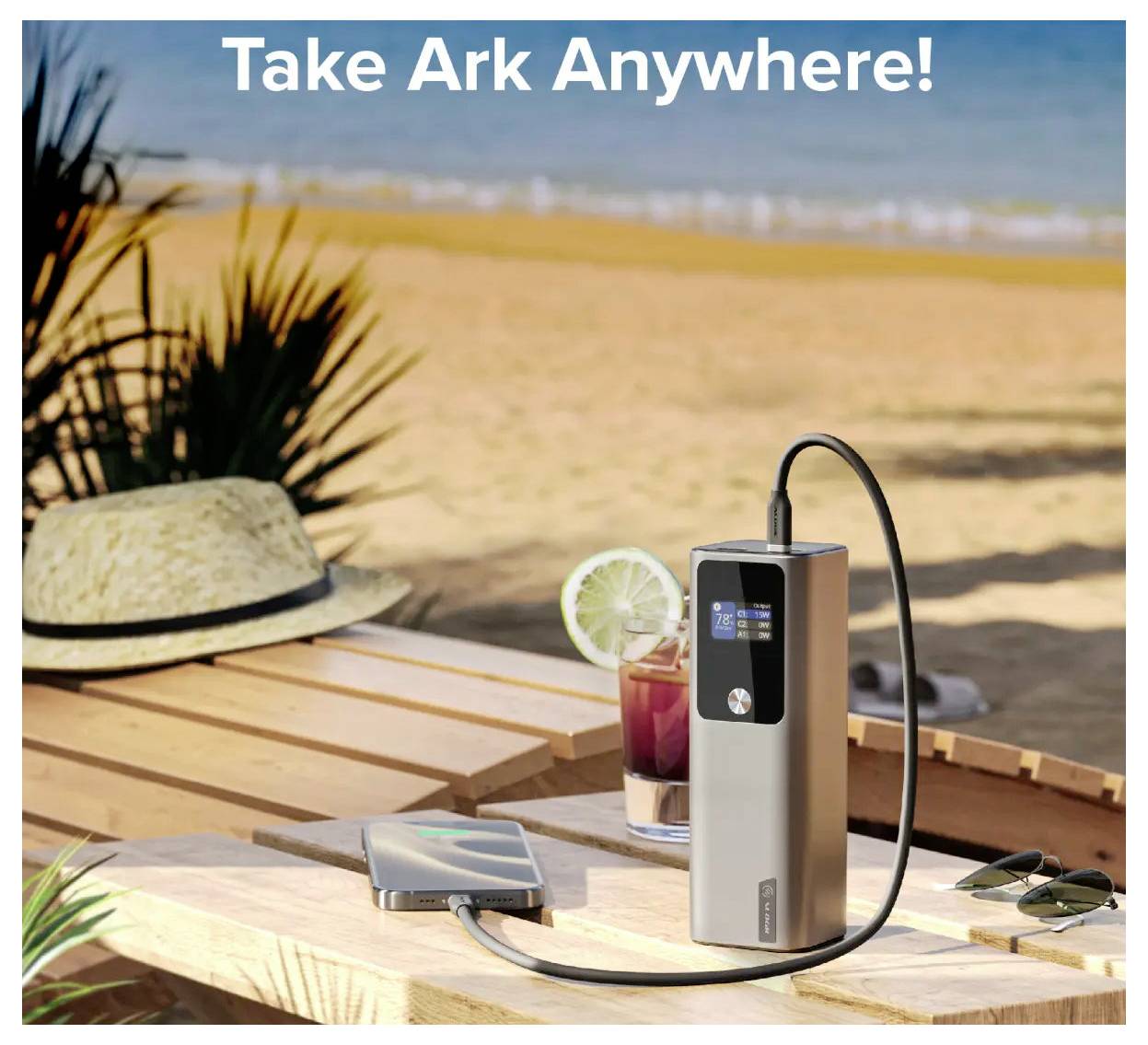 Appareil de charge portable sur une table au bord de la plage, en train de charger un téléphone. Un verre, un chapeau et la plage sont visibles en arrière-plan. Texte : « Emportez Ark Partout ! »