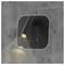 Lampe murale noire avec tête cylindrique ajustable, deux ports USB et deux boutons de commande. La lumière est projetée sur un mur gris texturé.