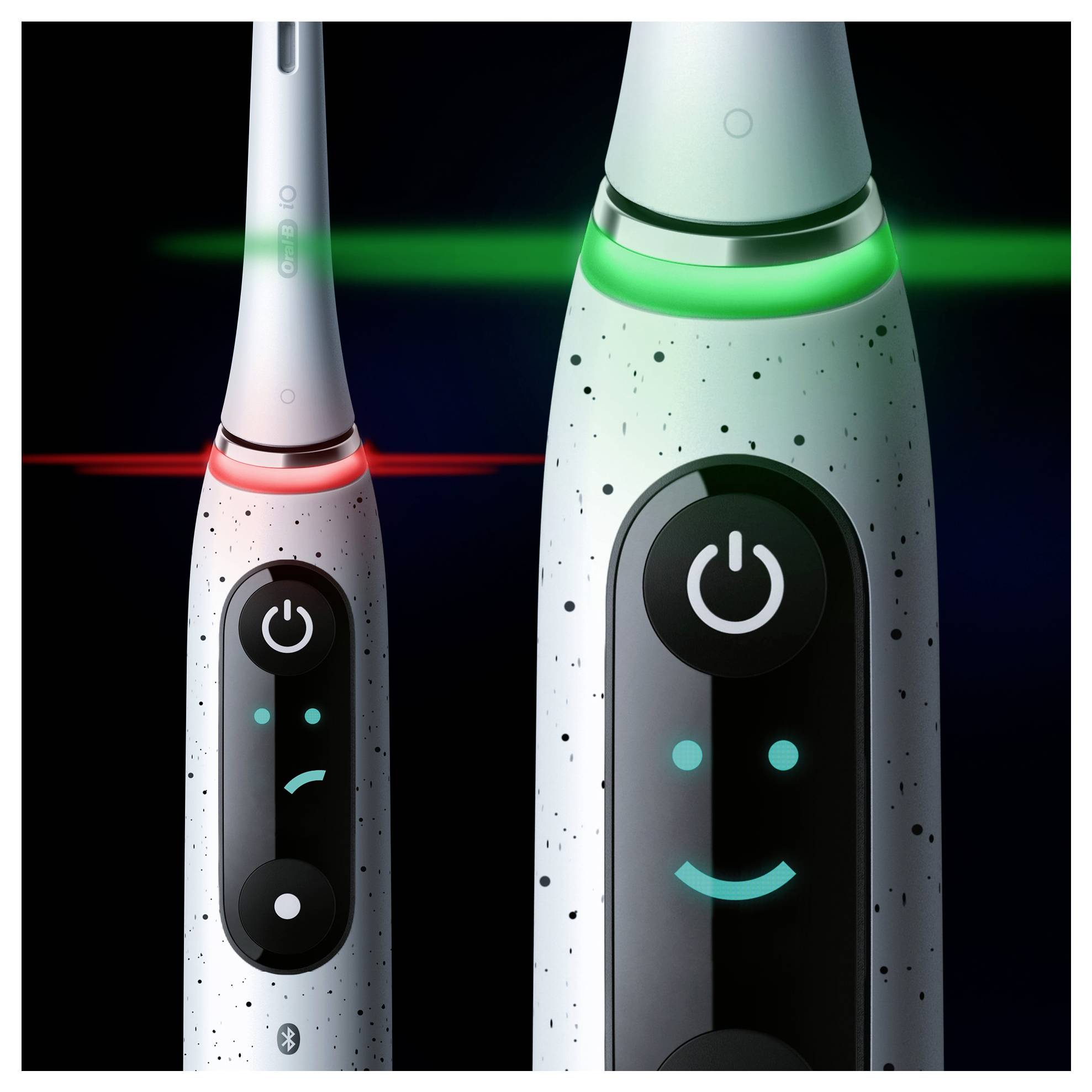 Brosses à dents électriques dotées de boutons marche/arrêt lumineux et d'écrans numériques, l'une avec un sourire et un voyant vert, l'autre avec une moue et un voyant rouge.