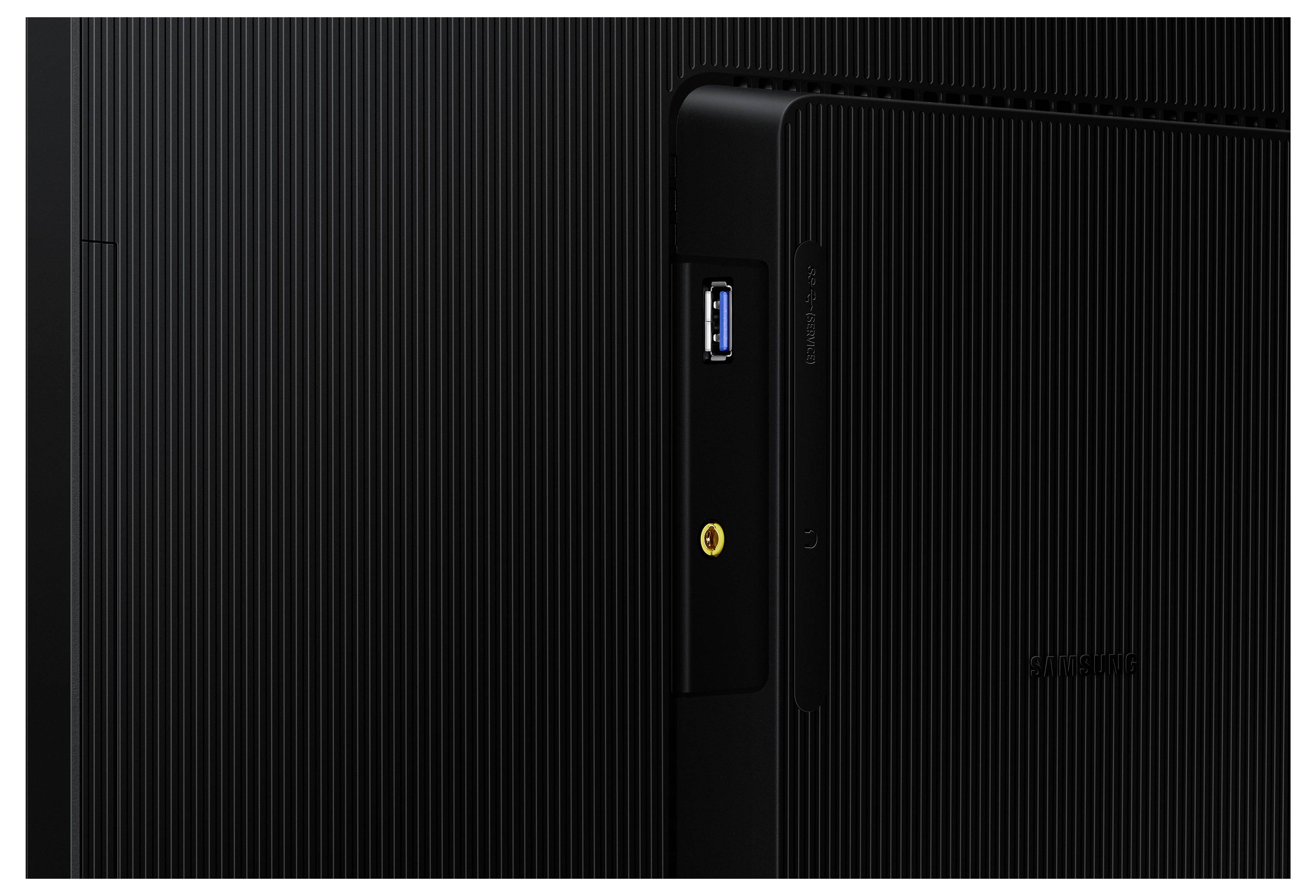 Un gros plan d'un appareil électronique noir montrant un port USB et un connecteur jaune sur le côté, sur un fond à surface texturée et striée.