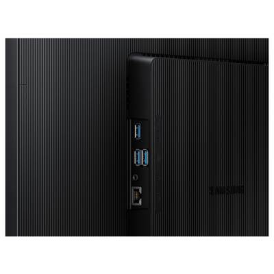 Arrière d'un appareil électronique noir présentant des ports, notamment des connexions USB et Ethernet, sur une surface texturée, avec la marque Samsung visible.