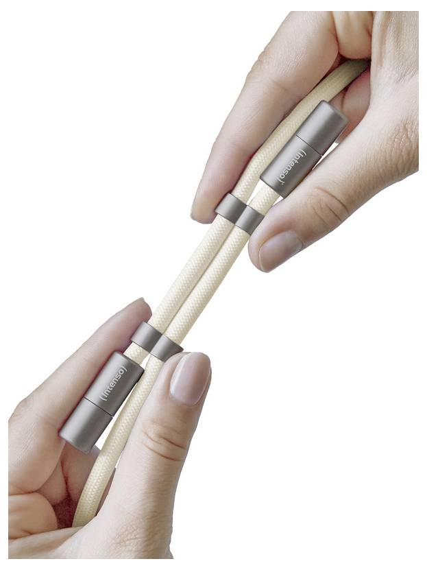 Deux mains tiennent un câble tressé beige avec des connecteurs métalliques étiquetés « Nomad », mettant en valeur la durabilité et le design du câble.