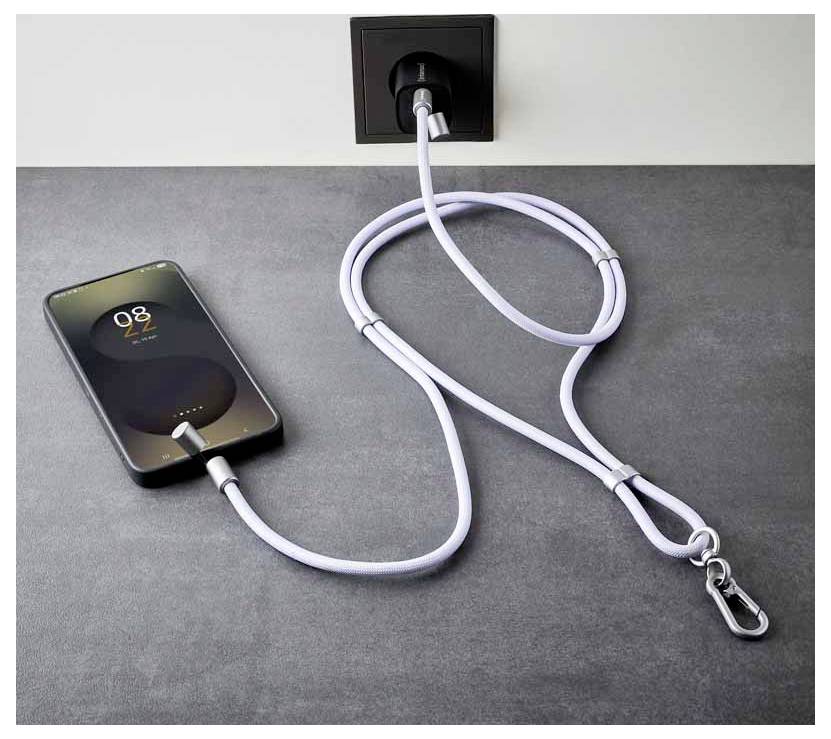 Un smartphone est en train de charger sur une table, relié par un long câble bouclé à une prise murale. L'écran du téléphone affiche '08:28' et une icône de verrouillage.