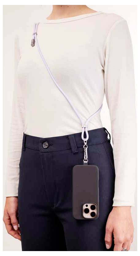 Une personne portant une chemise blanche à manches longues et un pantalon noir présente un smartphone suspendu à une bandoulière traversant le corps, mettant en valeur le transport mains libres du téléphone.