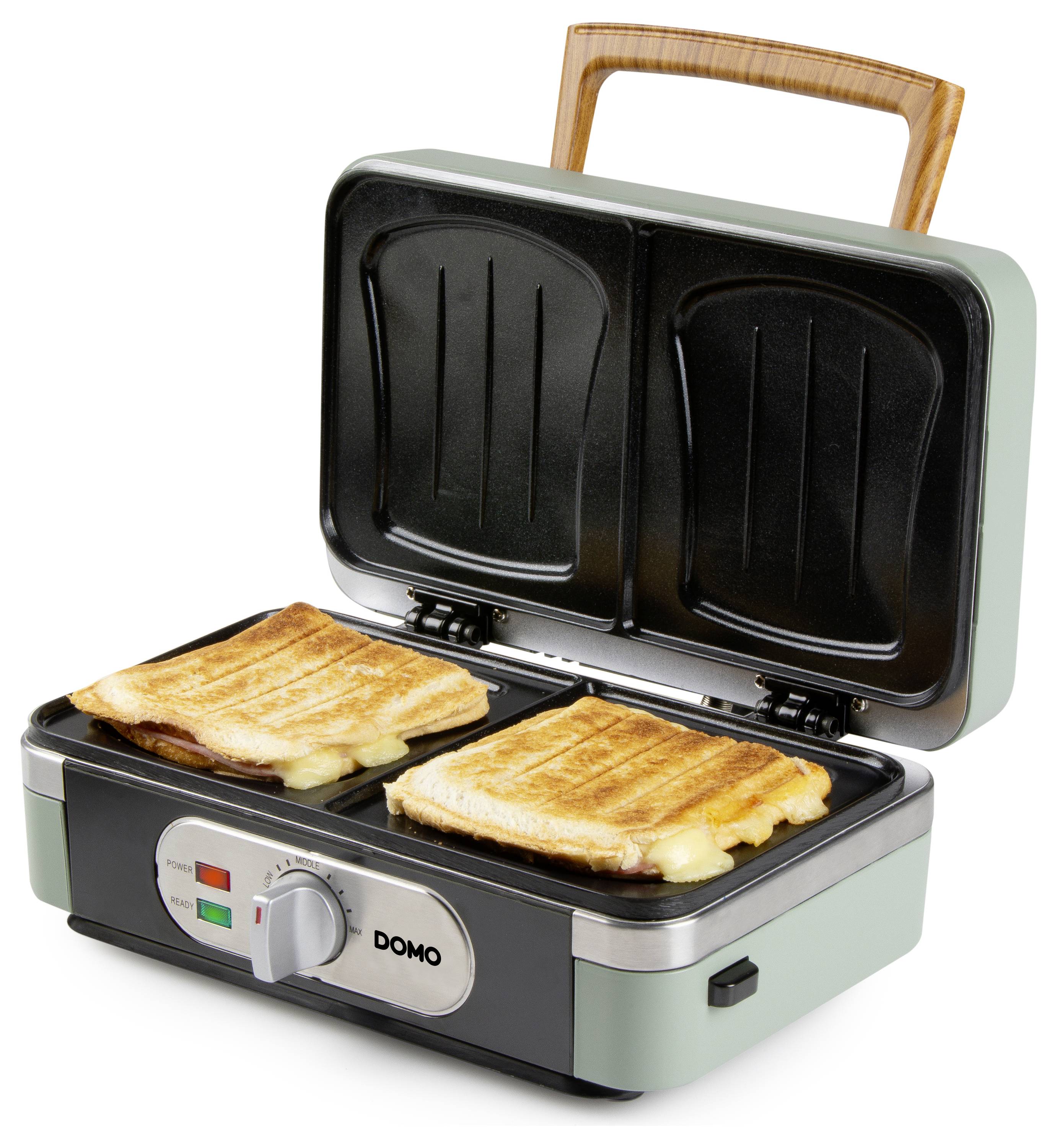 Un grille-pain à sandwich ouvert en train de griller deux sandwichs. Les sandwichs ont du fromage fondu qui déborde, et l'appareil est posé sur un plan de travail.