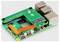 Un ordinateur monocarte Raspberry Pi doté de plusieurs ports USB, d'un port Ethernet et d'un câble ruban visible sur un fond uni et propre.