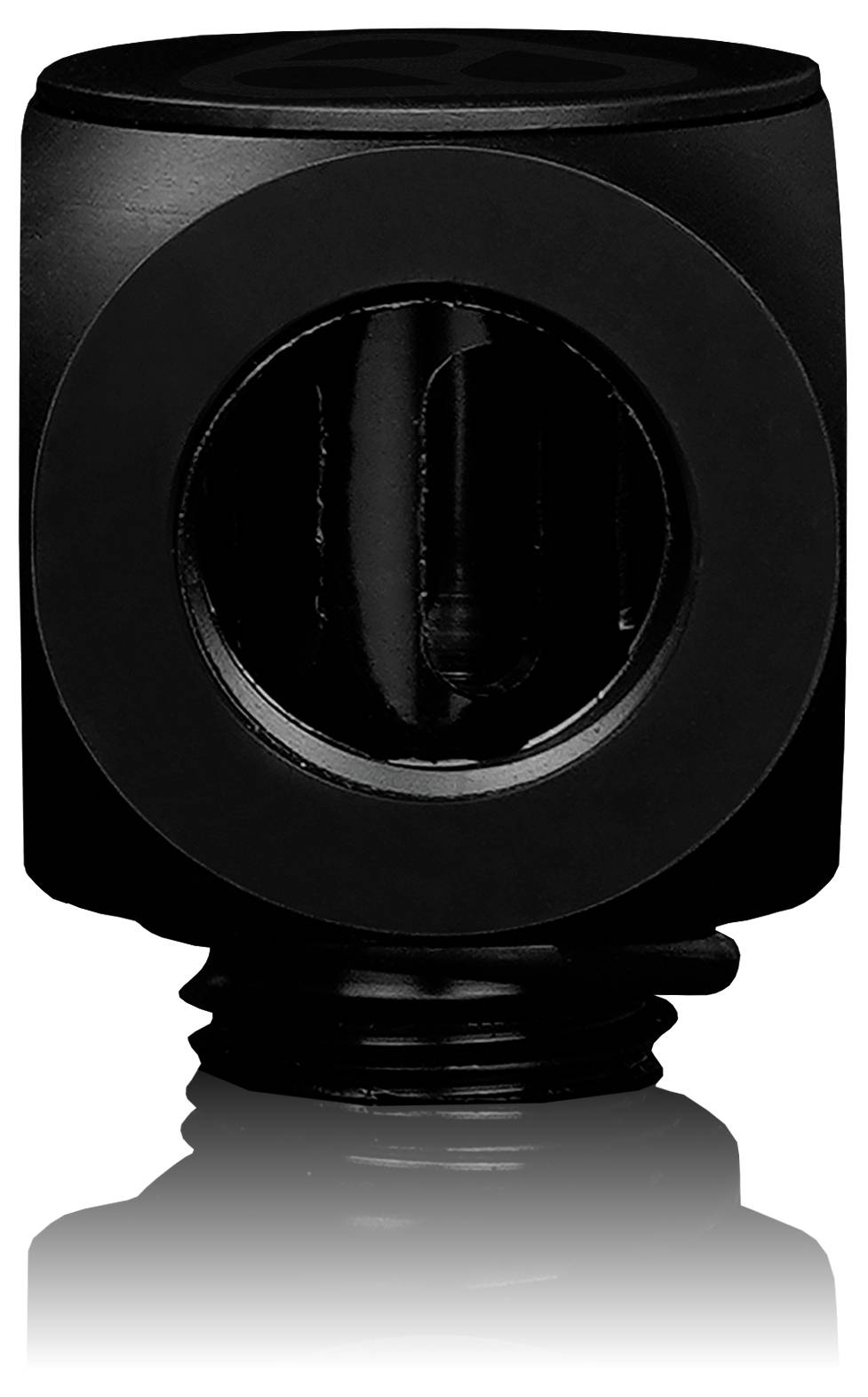 Un objet cylindrique noir avec une ouverture circulaire visible en son centre, posé sur une surface réfléchissante.