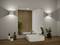 Une salle de bain moderne avec un lavabo carré, un grand miroir et un comptoir en bois. Deux plantes en pot et des distributeurs de savon sont soigneusement disposés.