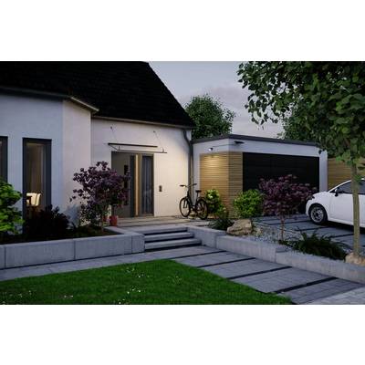 Maison moderne avec un chemin, une entrée éclairée, des arbustes, un vélo près de la porte, et un garage avec une voiture garée à côté au crépuscule.