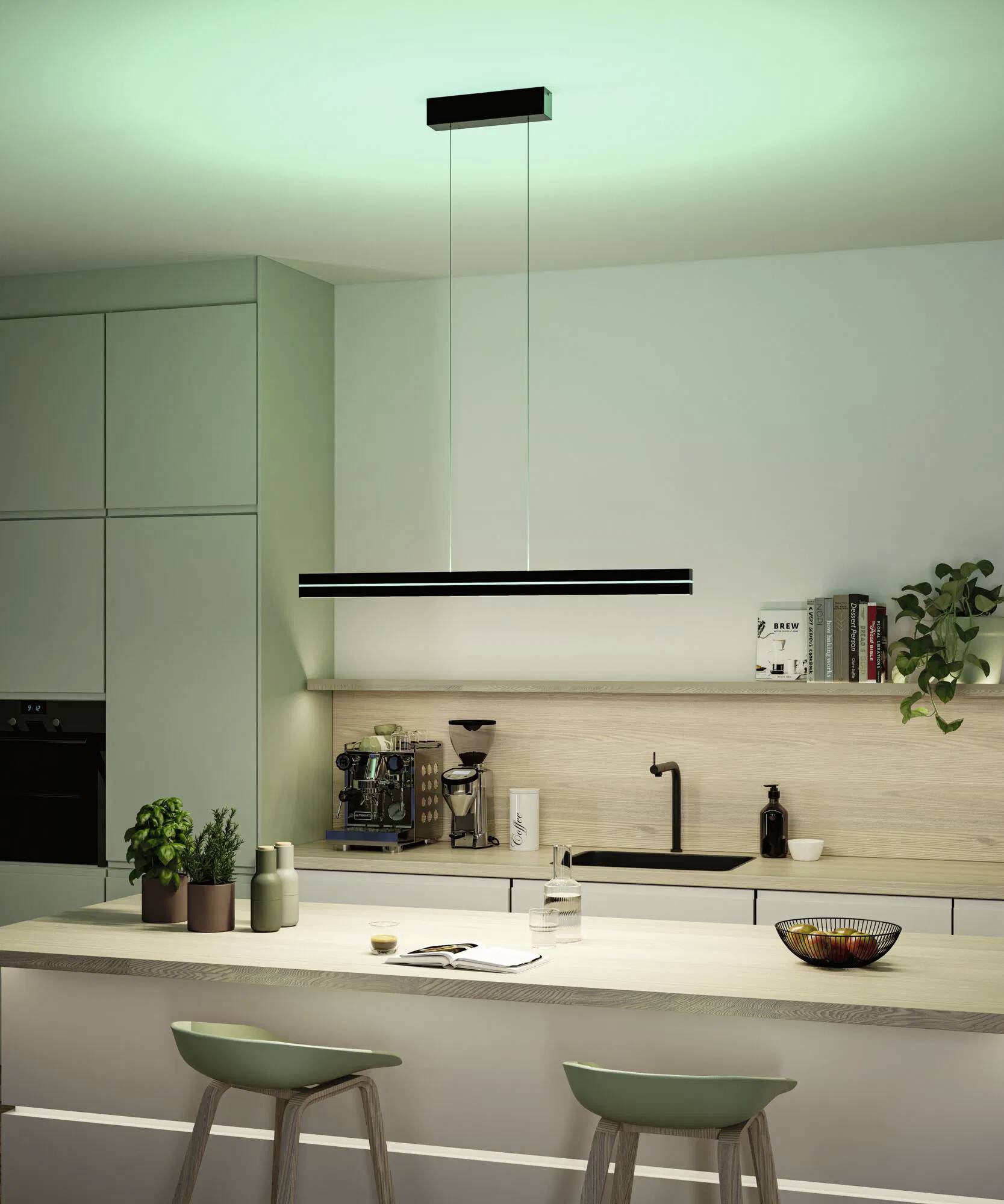 Une cuisine moderne avec un éclairage vert, comprenant un îlot central équipé de deux tabourets de bar, une suspension lumineuse et des armoires épurées.
