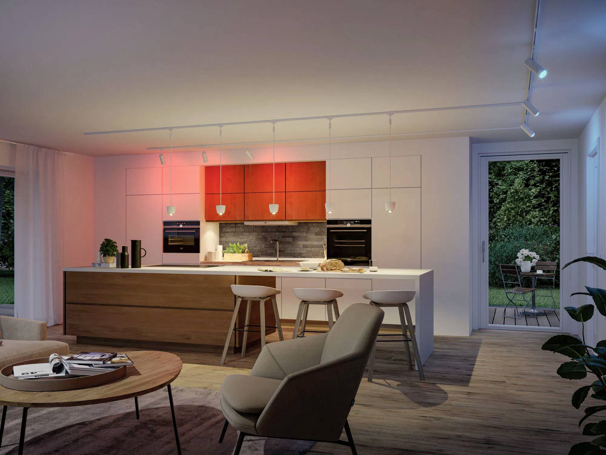 Une cuisine moderne avec un éclairage intelligent ; le design épuré comprend un îlot central avec des tabourets de bar, des luminaires suspendus et de grandes fenêtres donnant sur un jardin.