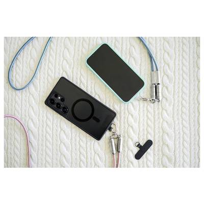 Deux smartphones, l'un noir et l'autre turquoise, munis de lanières, sont posés sur une surface texturée. Un petit accessoire noir se trouve à proximité.