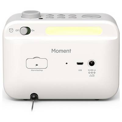 Un appareil électronique blanc étiqueté 'Moment' comprend un interrupteur marche/arrêt, une sauvegarde d'alarme, un port USB et une entrée d'alimentation, avec un cadran de contrôle sur le dessus.