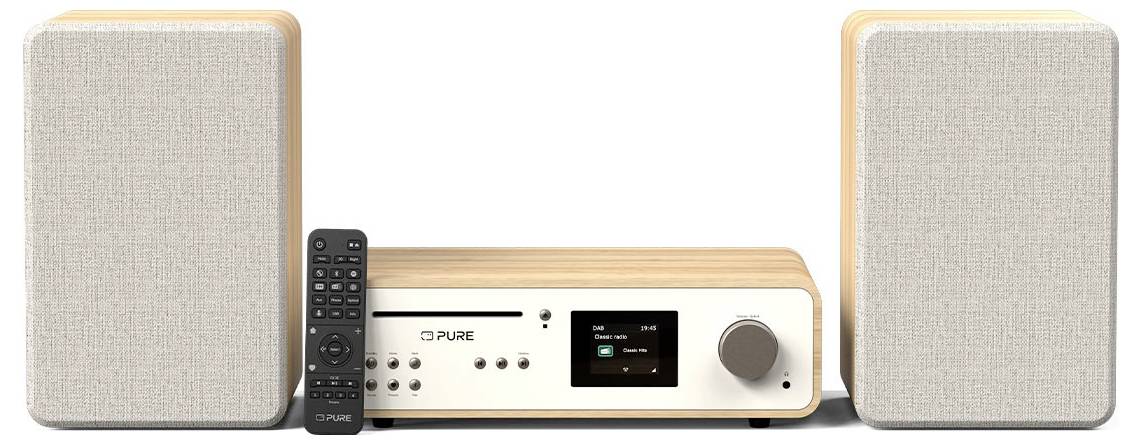 Un système audio compact avec deux enceintes beiges et une unité centrale dotée d'un écran, de boutons de contrôle et d'une télécommande, posé sur un support en bois clair.