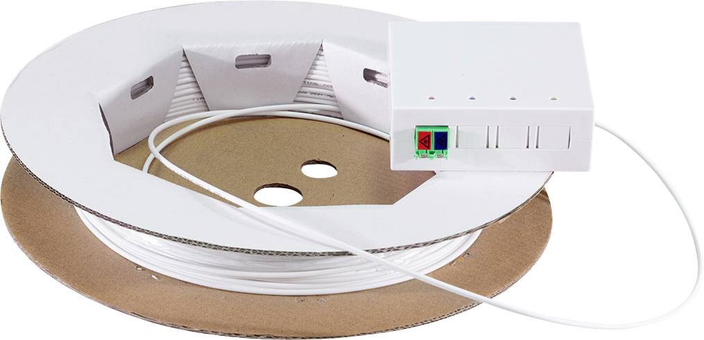 Une bande de câble plate et blanche enroulée sur une bobine en carton, avec un dispositif électronique blanc connecté affichant des voyants lumineux et deux ports.