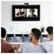 Des personnes dans une salle participant à une vidéoconférence avec quatre individus à l'écran, illustrant un environnement de réunion virtuelle.