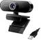 Une webcam noire avec un clip intégré et un câble de connexion USB. L'objectif est centré avec un design circulaire, adaptée aux appels vidéo.