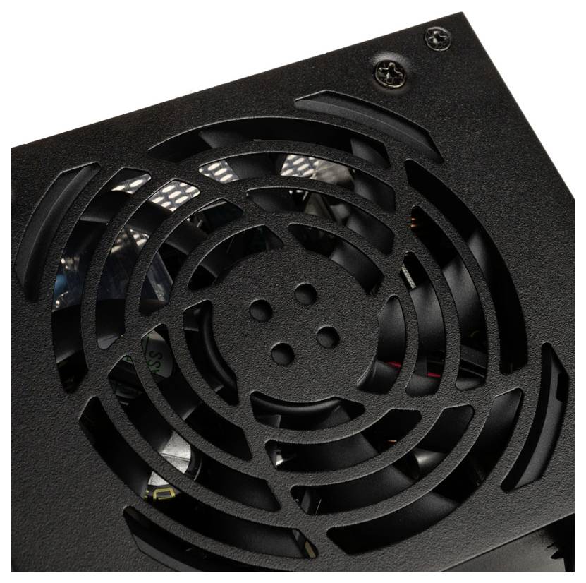 Un gros plan d'un bloc d'alimentation d'ordinateur avec un ventilateur visible et une grille métallique, montrant des vis dans le coin supérieur pour le montage.