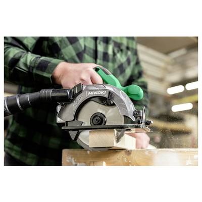 Une personne utilise une scie circulaire Hikoki pour couper une planche en bois dans un atelier. Des copeaux de sciure sont visiblement projetés depuis la zone de coupe.