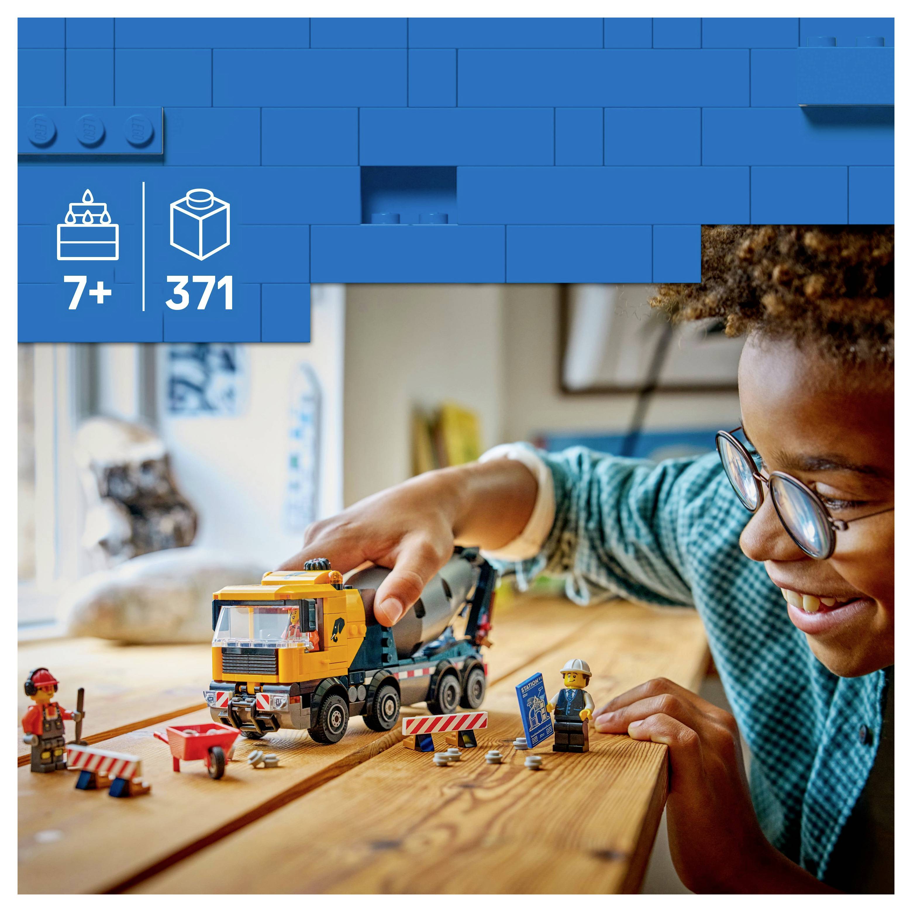 Un enfant joue avec un jeu de camion de construction sur une table. L'emballage indique « 7+ 371 pièces ».
