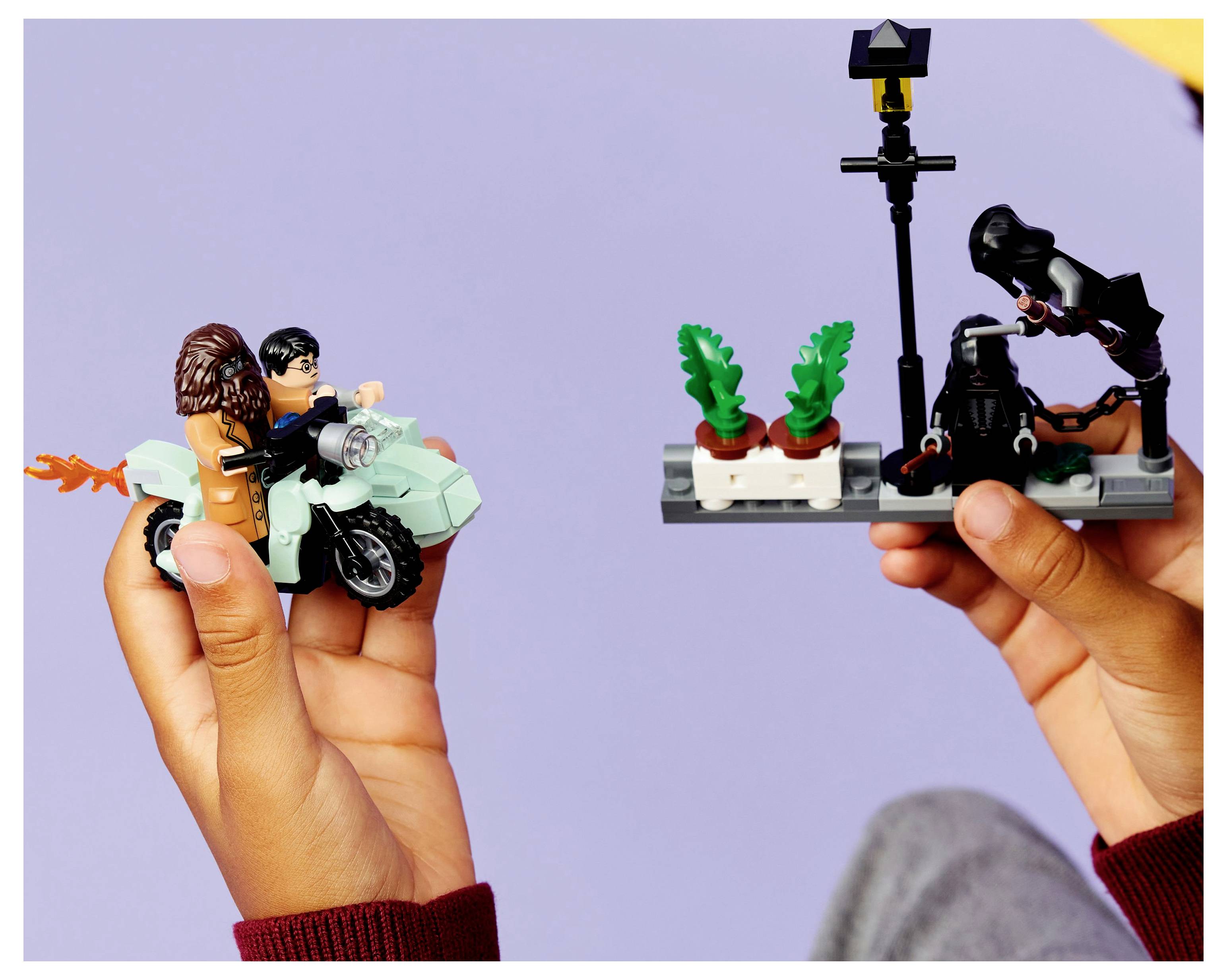 Deux mains tiennent des scènes LEGO contrastées : l'une avec une motocyclette et des personnages, l'autre avec un petit jardin et un personnage s'occupant des plantes.
