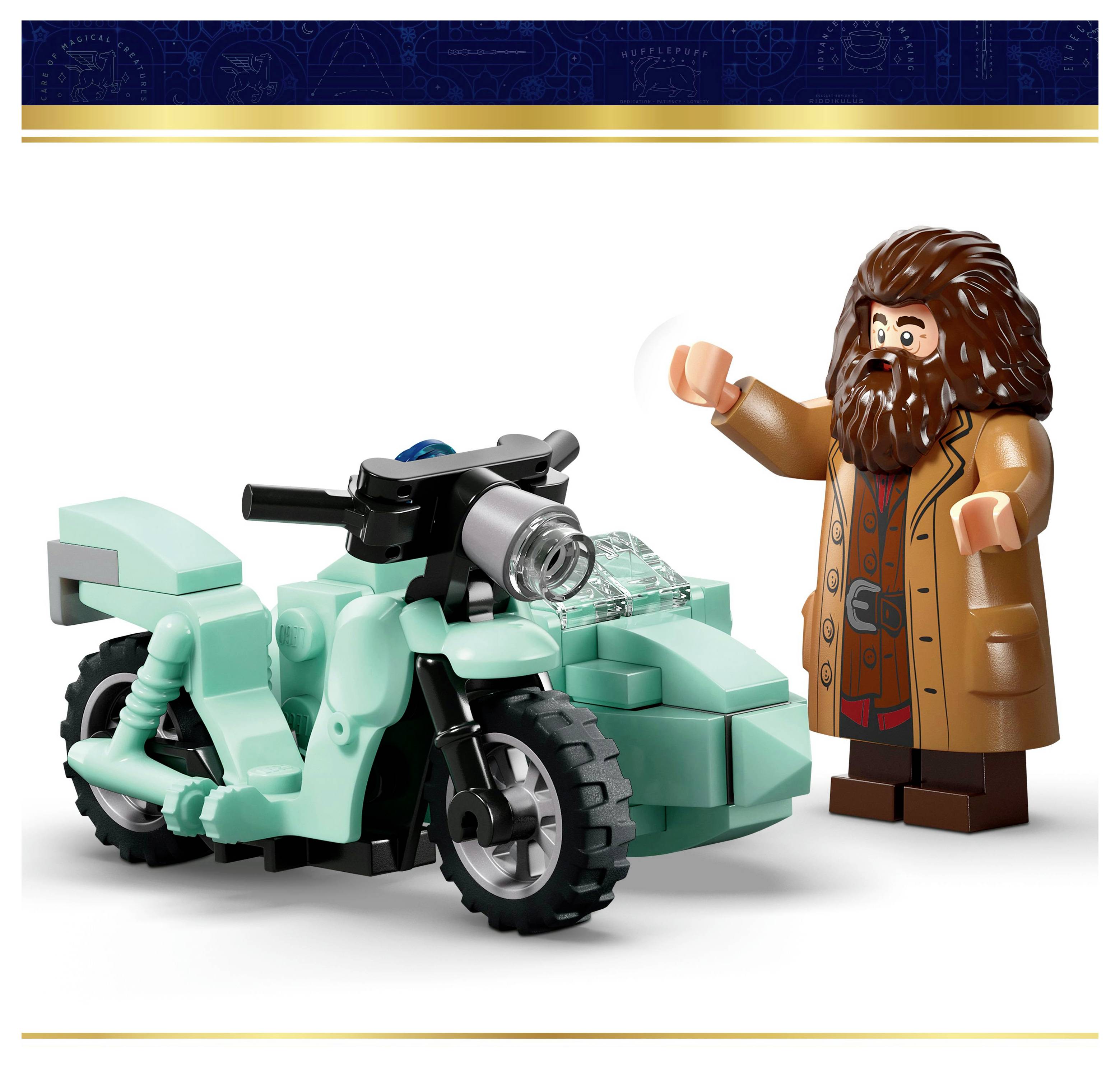 Une figurine aux cheveux longs et à la barbe, portant un manteau marron, se tient à côté d'une moto jouet turquoise, semblant faire un geste de salut ou de la main.