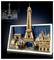 Modèle de la Tour Eiffel en LEGO posé devant un ensemble de bâtiments parisiens, avec un croquis architectural détaillé dans le coin supérieur gauche.