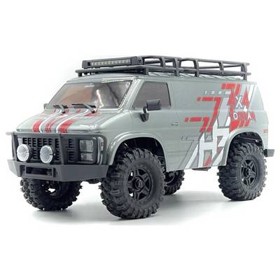 Un van tout-terrain gris 4x4 avec des décalcomanies rouges et blanches, doté de grands pneus et d'un porte-bagages de toit, incliné vers la gauche pour mettre en valeur son design robuste.