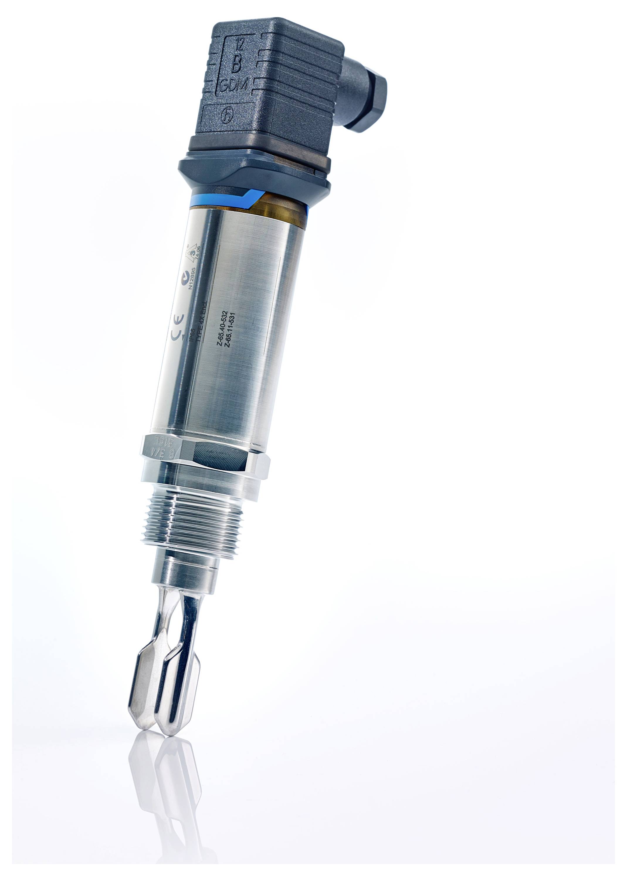Un capteur industriel métallique avec un corps cylindrique et une sonde, incliné sur une surface réfléchissante. Il présente des composants de connecteur électrique.
