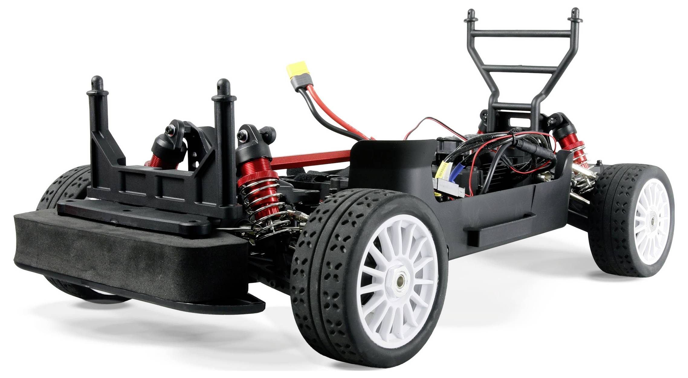 Un châssis de voiture télécommandée noir et rouge avec un câblage apparent, une suspension visible et des roues blanches, dépourvu de carrosserie.