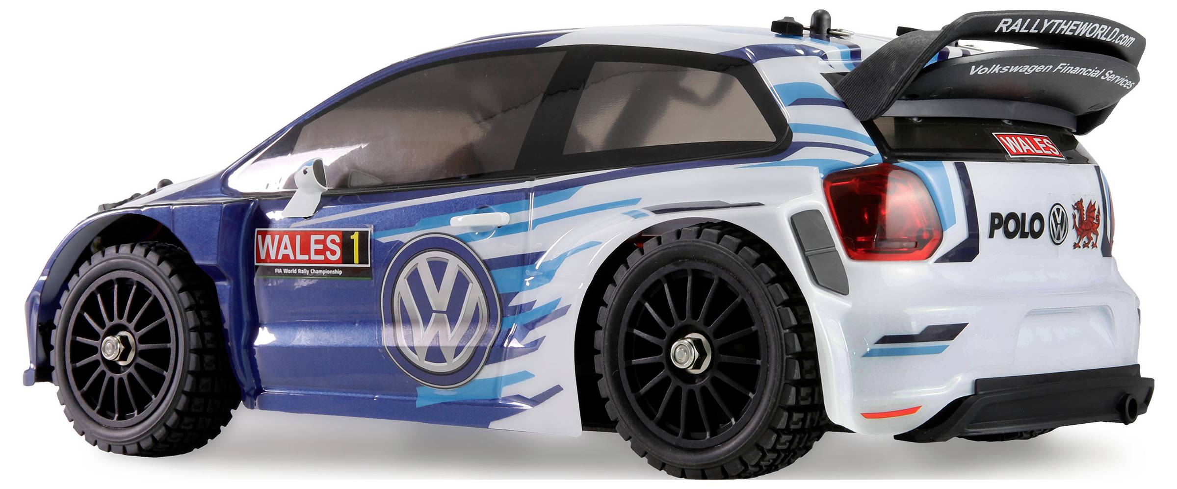 Une voiture de rallye miniature bleue et blanche avec des autocollants 'WALES 1' et 'POLO R WRC', équipée d'un aileron arrière et arborant un habillage de course détaillé.
