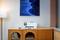 Un espace de bureau à domicile moderne présente un meuble en bois avec une imprimante et de petits cadres photos, sous une peinture abstraite bleue.