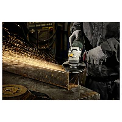 Un ouvrier portant un équipement de protection utilise une meuleuse d'angle, créant des étincelles brillantes en coupant une surface métallique dans un environnement industriel.