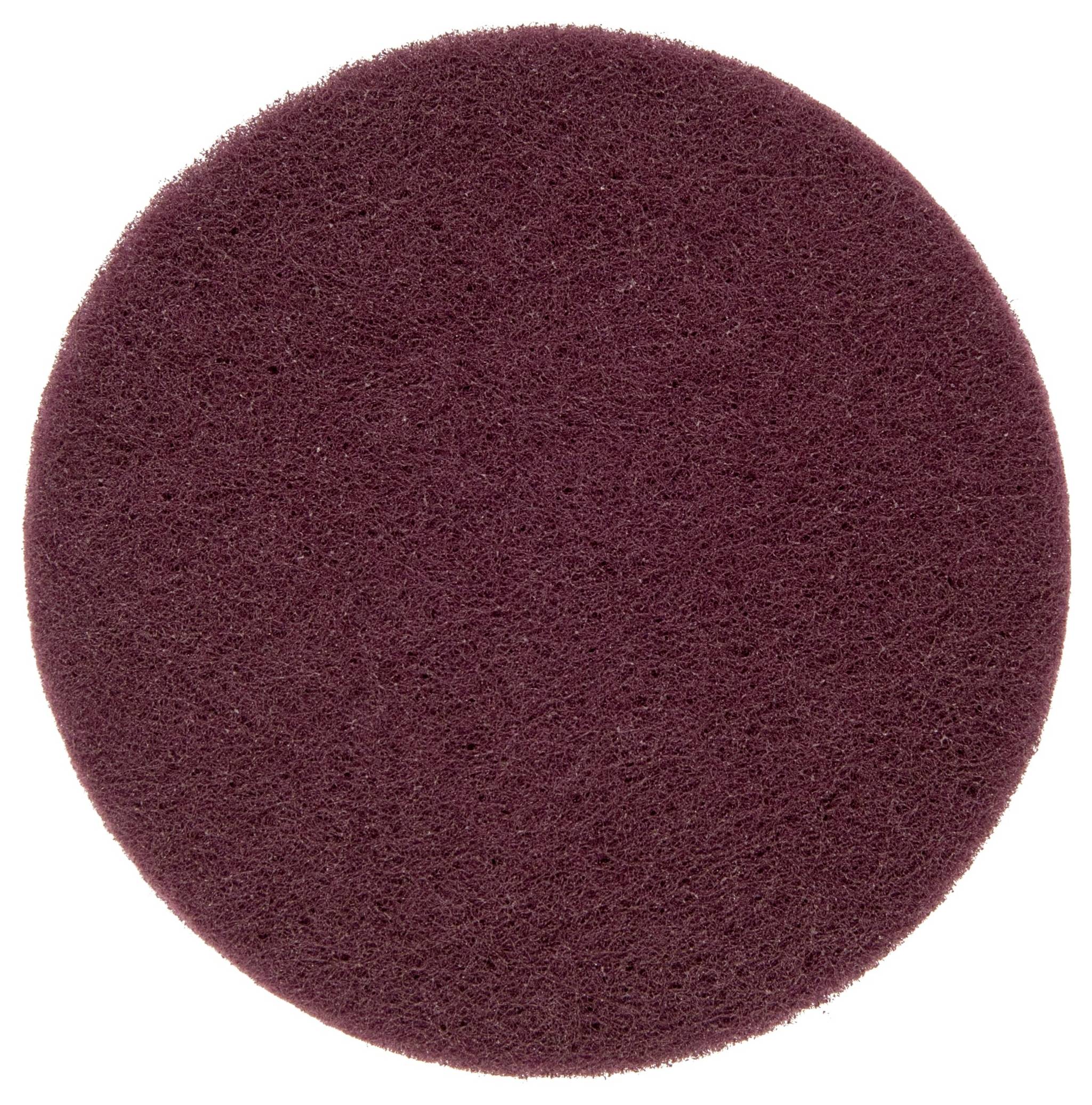 Une éponge circulaire de couleur marron, à texture rugueuse, utilisée pour nettoyer des surfaces.
