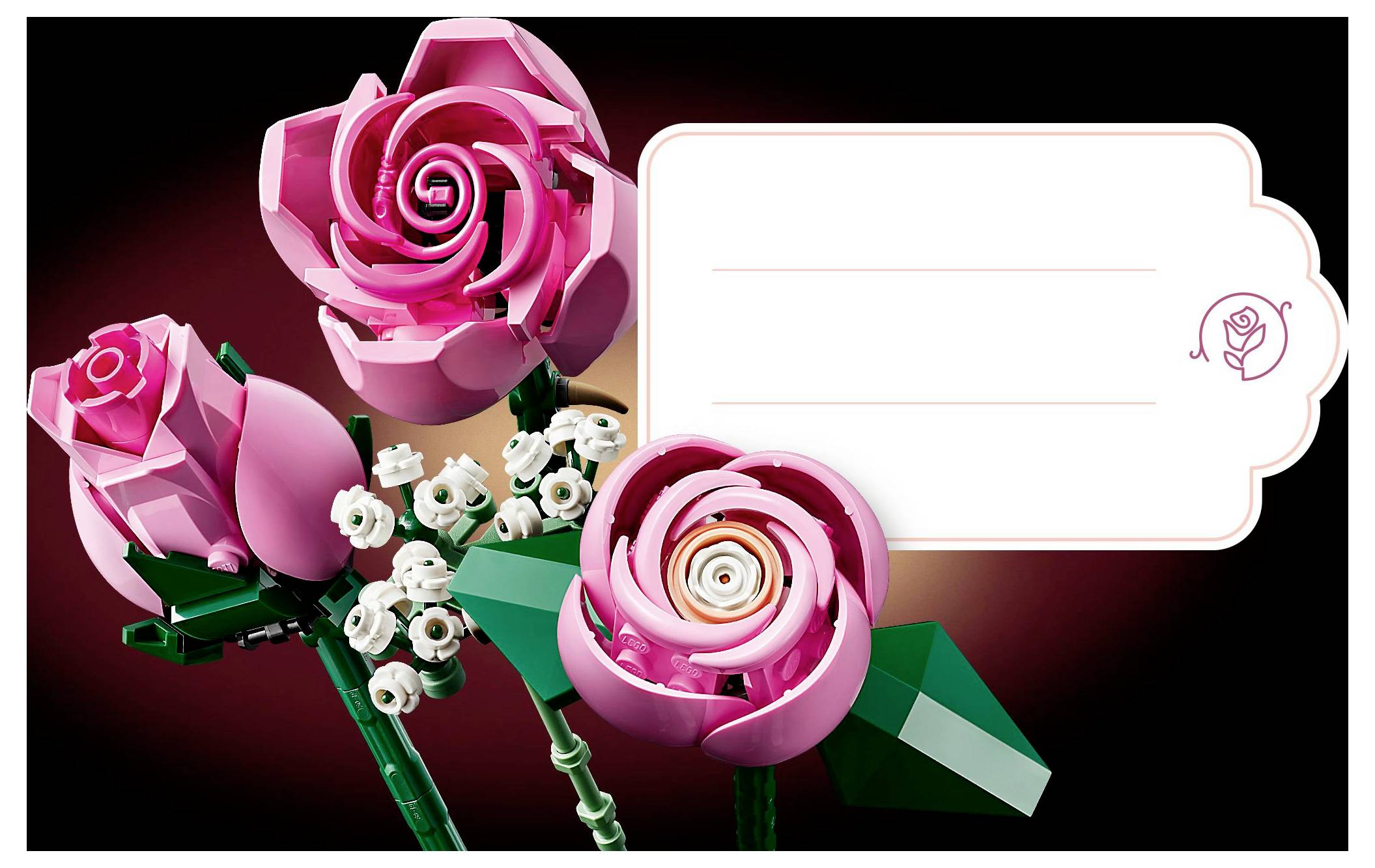 Affichage floral LEGO présentant des roses roses et des fleurs blanches. Étiquette vierge avec icône de rose sur la droite, possiblement destinée à la personnalisation.