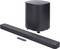Une barre de son élégante en noir et un caisson de basses cylindrique avec une télécommande, présentant un équipement audio domestique moderne.