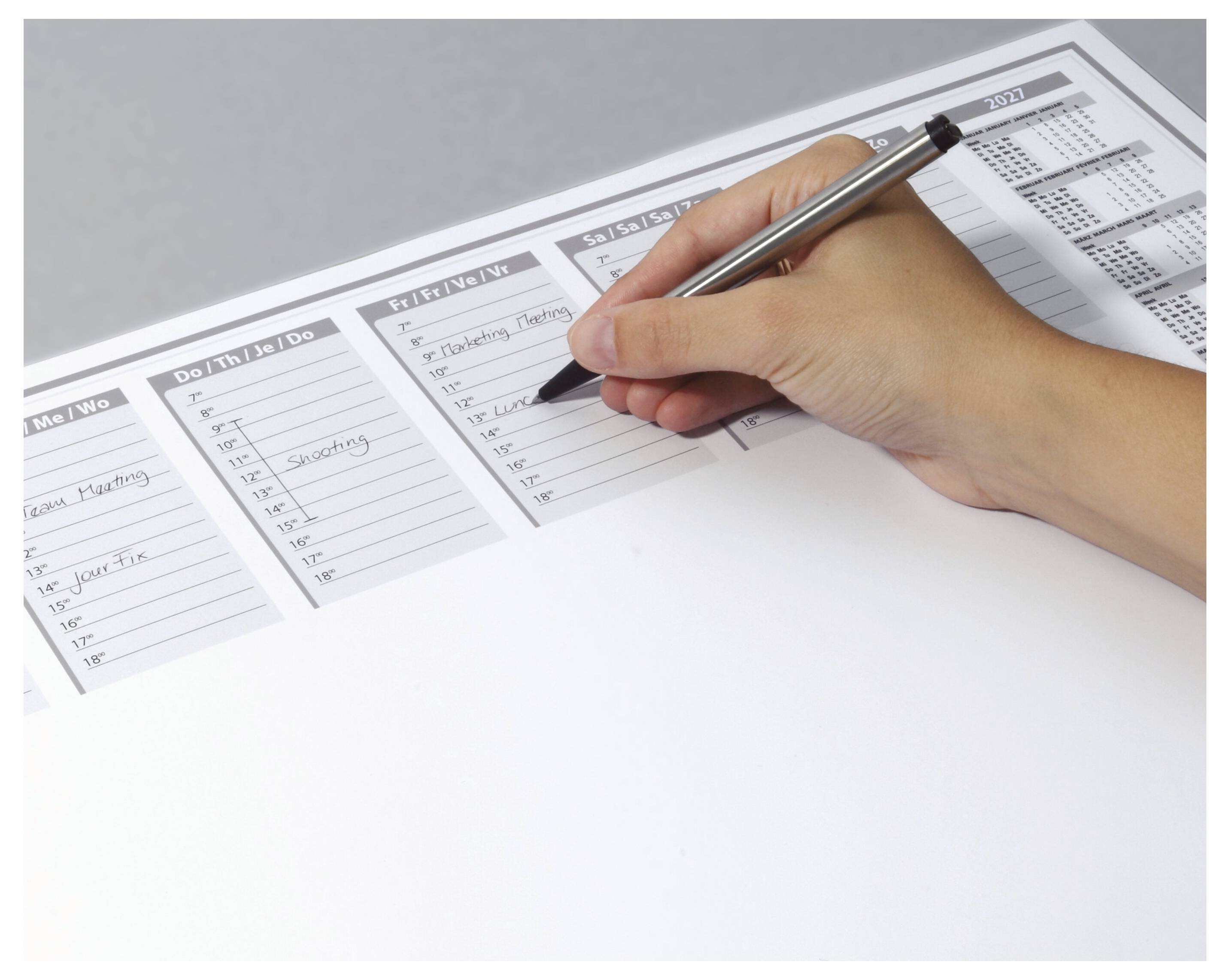 Une personne inscrit des tâches dans un agenda hebdomadaire sous différentes catégories, dont « À faire », « Cette semaine » et « Semaine prochaine ».