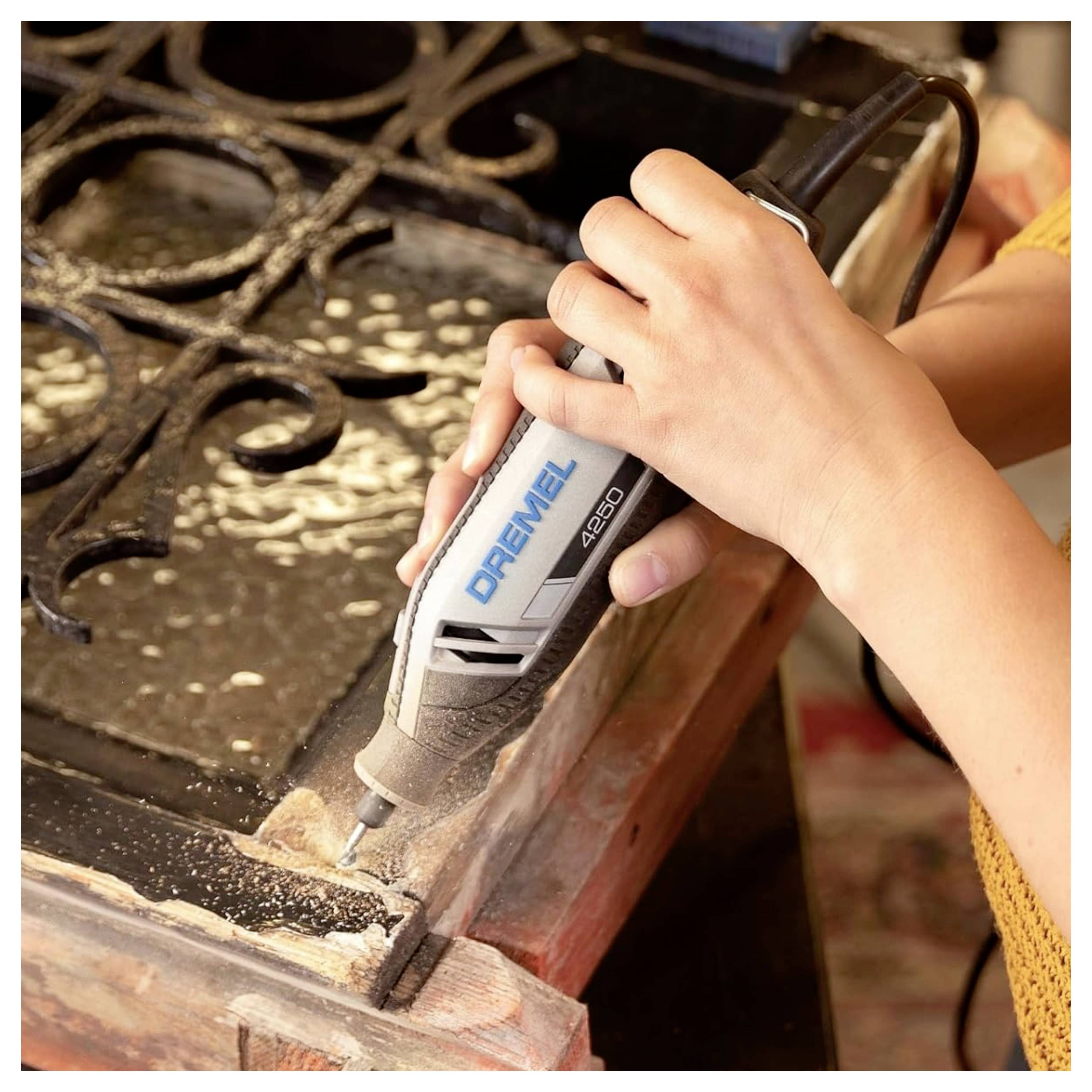 Une personne utilise un outil rotatif pour graver ou sculpter du bois, en se concentrant sur des détails précis. L'outil est étiqueté « DREMEL 4300 ».