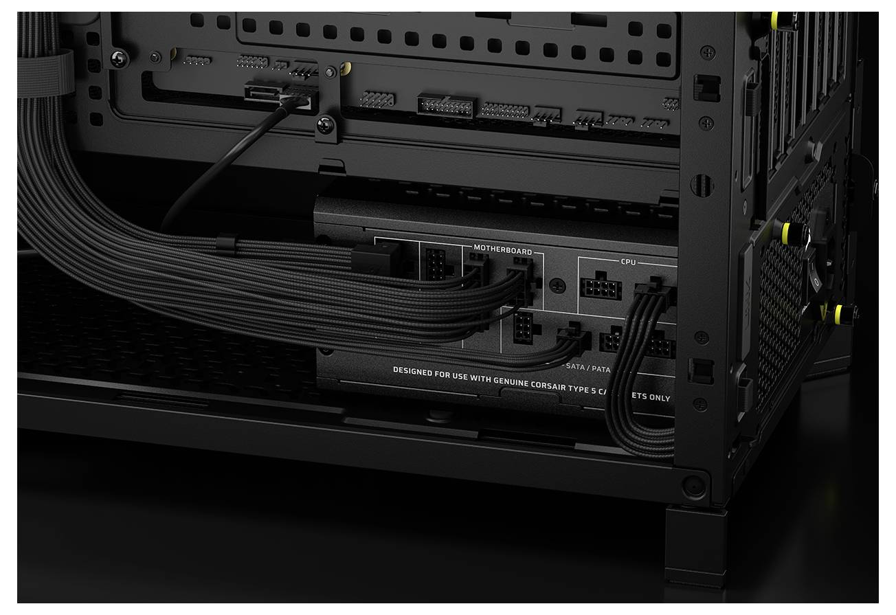 Gros plan de l'intérieur d'un boîtier d'ordinateur, mettant en valeur une alimentation avec des câbles connectés à la carte mère et au processeur, soulignant la gestion organisée des câbles.
