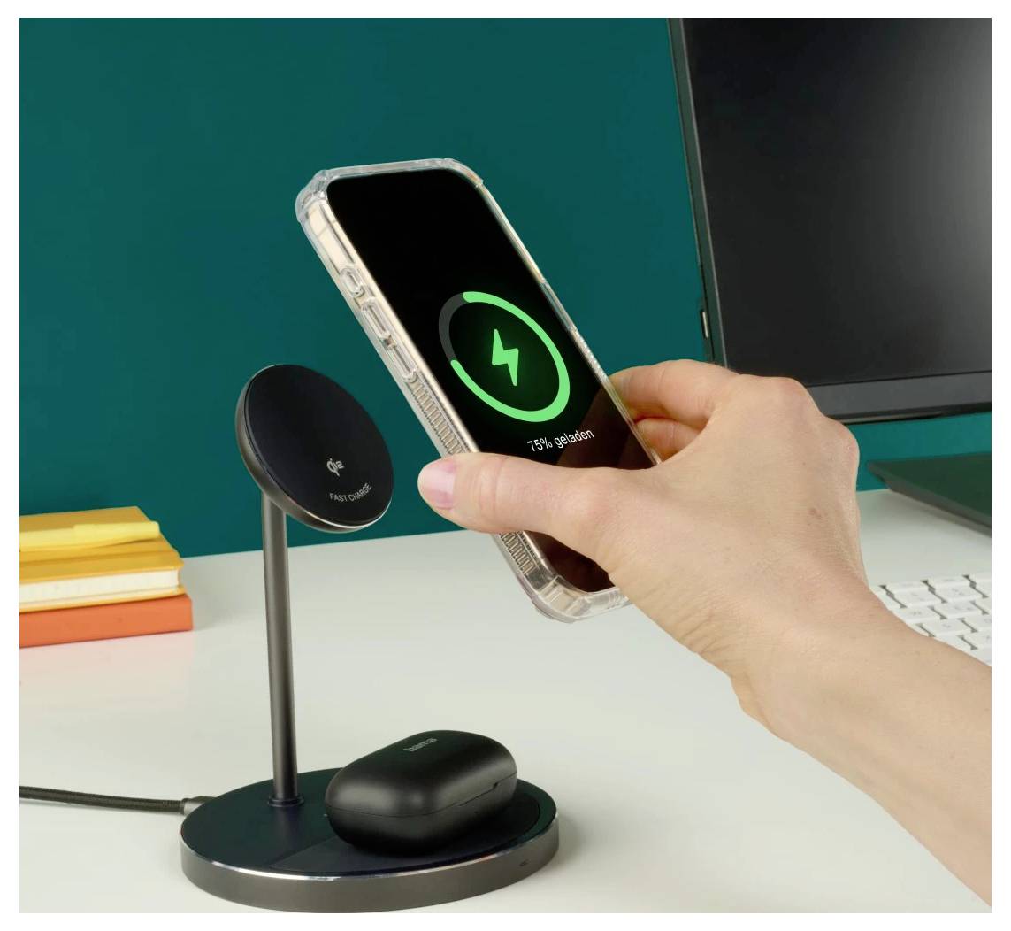 Une main pose un smartphone sur un support de charge sans fil sur un bureau. Le téléphone affiche « 75% de batterie ». Un boîtier de charge est posé sur le support.