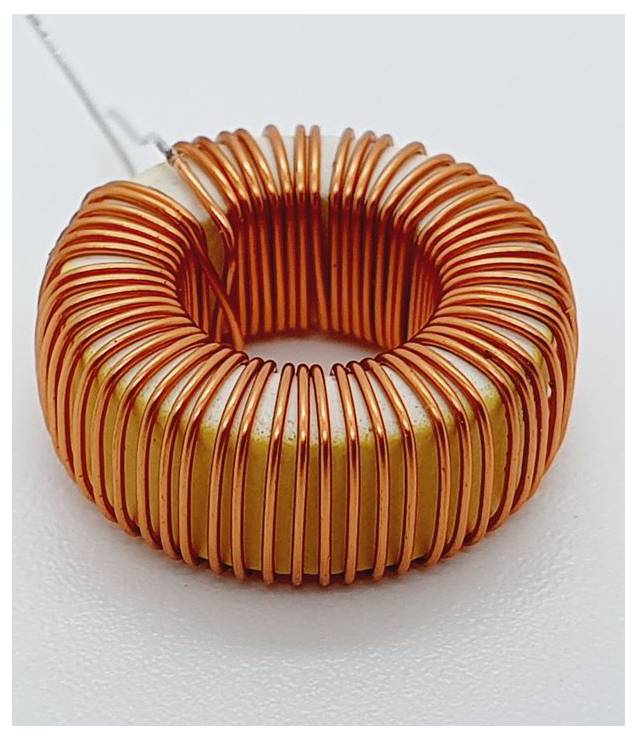 Une bobine en forme de donut faite de fil de cuivre orange enroulé étroitement autour d'un noyau, utilisée comme inducteur dans des applications électroniques.