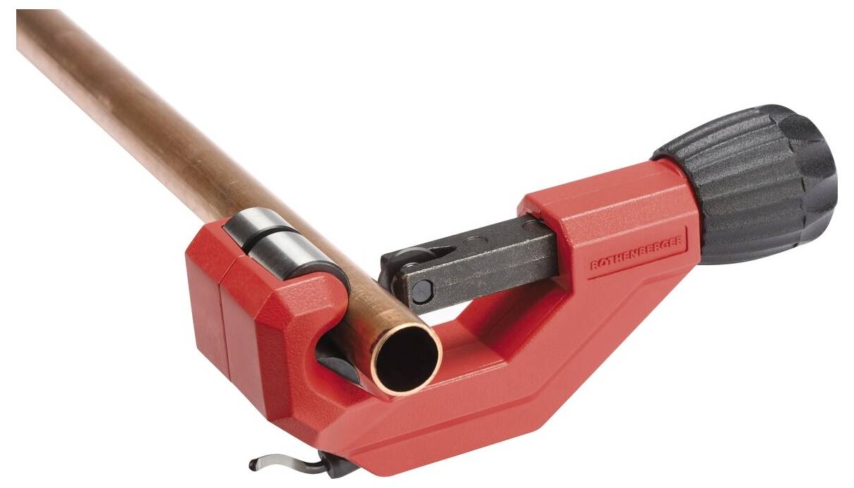 Un coupe-tube avec une poignée rouge est fixé sur un tuyau en cuivre, démontrant son utilisation prévue pour couper des tuyaux.