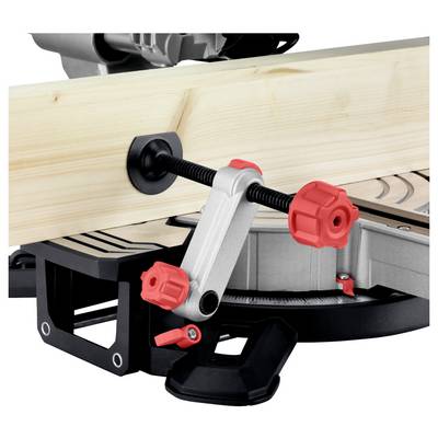 Un morceau de bois maintenu par une pince rouge dans une scie à onglets, indiquant une configuration pour la coupe.